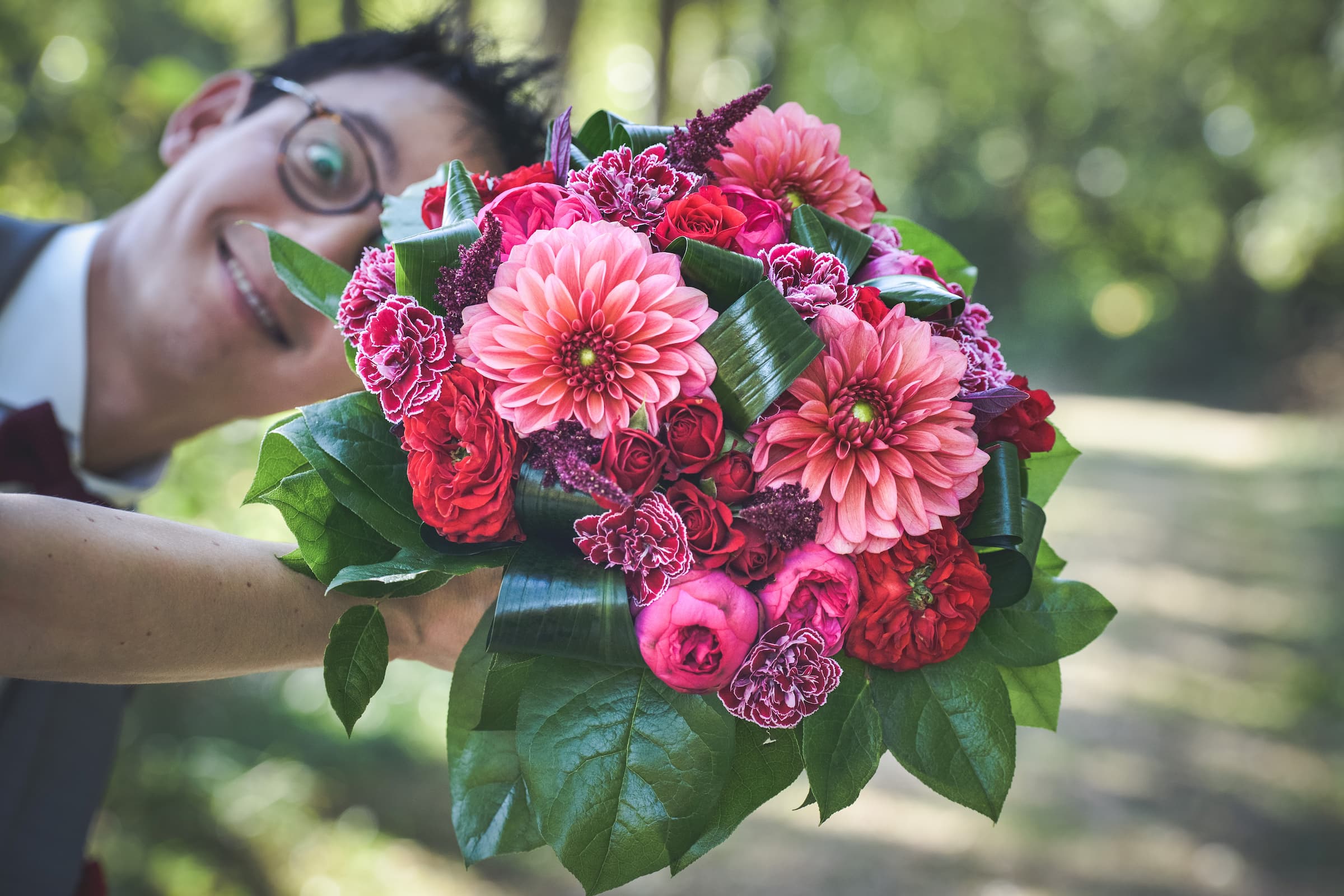 homme qui fait un photo bomb derriere un bouquet de mariage