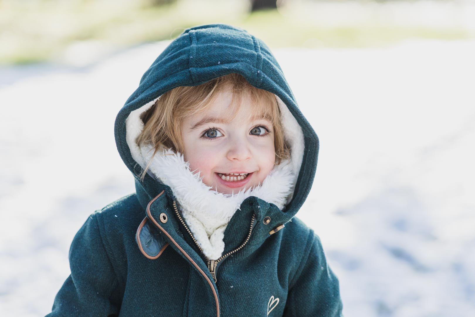 fillette qui porte un manteau vert dans la neige